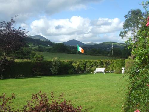 a flag flying in a yard with a bench at River Meadows B&B in Kenmare