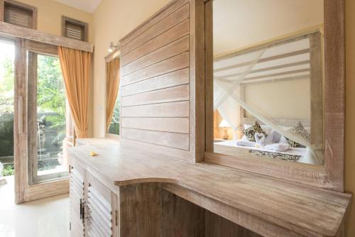 烏布的住宿－巴厘島烏布阿拉姆普拉切塔旅館，一间带大镜子和盥洗盆的浴室