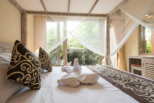 Una cama o camas en una habitación de Alam Pracetha Bali Ubud