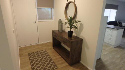 a mirror and a plant on a dresser in a room at A-Line Holiday Park in Bendigo