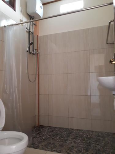 ein Bad mit einer Dusche, einem WC und einem Waschbecken in der Unterkunft Bajawa-Roo Hotel in Bajawa