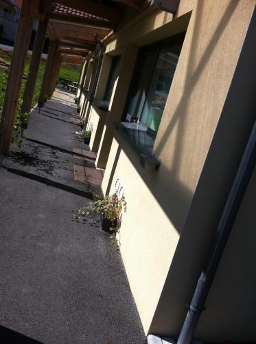a shadow of a building with plants on the side at Fasthôtel Le Râle Des Genêts - Un hôtel FH Collection in Dun-sur-Meuse