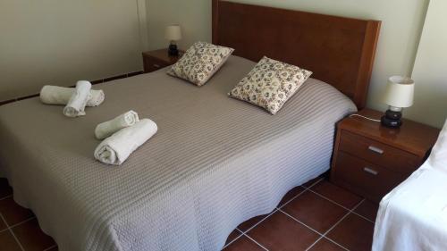 una camera da letto con un letto con due asciugamani arrotolati di Estrela do Mar - 100m da praia a Peniche