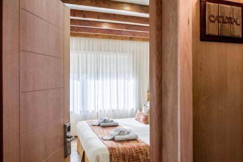 a bedroom with a bed with two towels on it at Hostería Antu Kuyen in San Carlos de Bariloche