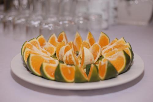 a plate with an orange dessert on a table at Lao Cai Royal Hotel in Lao Cai