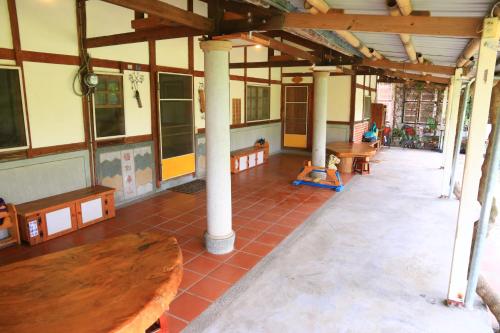 ein Zimmer mit Bänken und Tischen in einem Gebäude in der Unterkunft Inn By Tree in Fujin