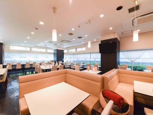 un ristorante con divani e tavoli e una sala da pranzo di Kobe Sannomiya Union Hotel a Kobe