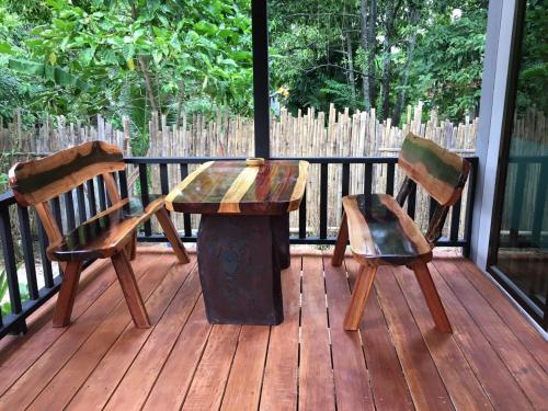 a wooden table and two chairs on a deck at Thai Terrace Bungalow in Thong Nai Pan Yai