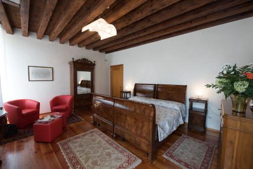 sypialnia z łóżkiem i czerwonym krzesłem w obiekcie Villa Curti w mieście Sovizzo