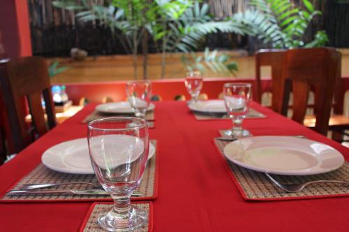 a red table with plates and glasses on a red table cloth at Bou Savy Villa in Siem Reap