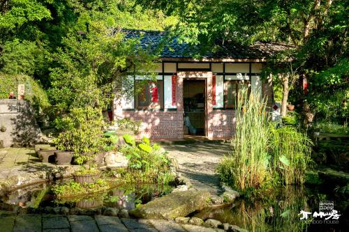 a small house with a pond in front of it at Bamboo House in Zhushan