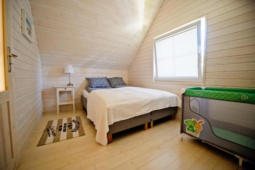 sypialnia z łóżkiem w małym pokoju w obiekcie Domki Na Brackiej w Pobierowie
