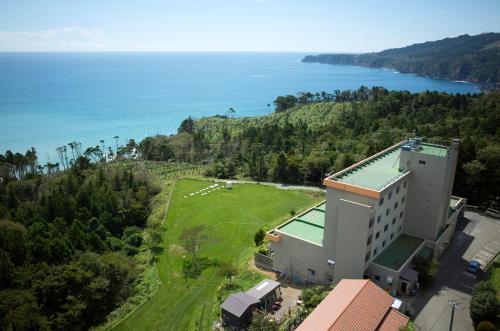 an aerial view of a building next to the ocean at Simamegurinoyado Sakai in Ishinomaki