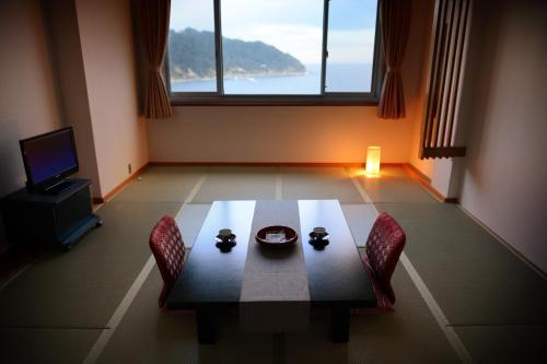 石巻市にあるSimamegurinoyado Sakaiのダイニングルーム(テーブル、椅子、窓付)