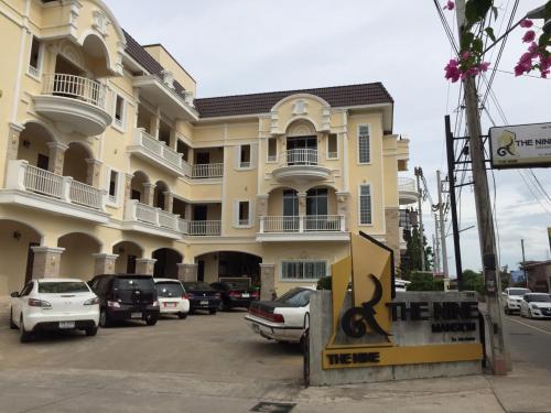 un grand bâtiment jaune avec des voitures garées dans un parking dans l'établissement The Nine Mansion, à Ubon Ratchathani