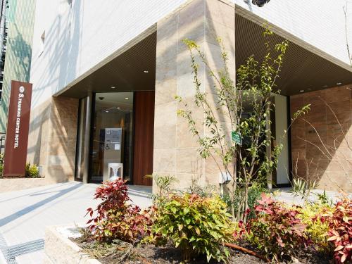 a building with some plants in front of it at S.Training Center Hotel Osaka in Osaka