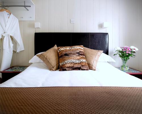 a bed with a pillow on top of it at Ammonite Lodge in Chard