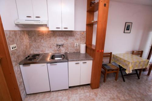 a small kitchen with a sink and a table at Apartments Viki in Podobuče