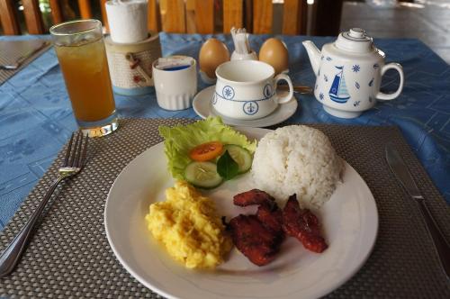 a plate of food with rice and meat and vegetables at Captain's Lodge and Bar in Panglao