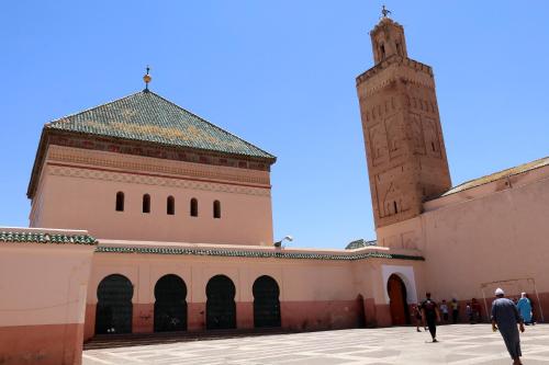 un edificio con una torre dell'orologio e una moschea di Riad Merstane Marrakech a Marrakech
