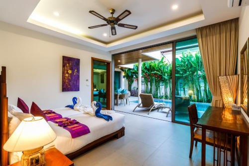 a bedroom with a bed and a dining room at Ka villa private pool & maid by Lofty in Rawai Beach