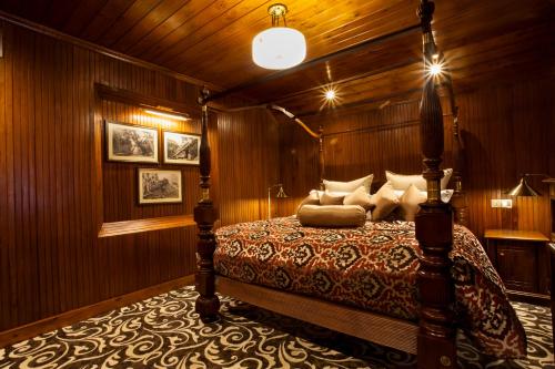 a bedroom with a bed in a wooden wall at La Grande Villa in Nuwara Eliya