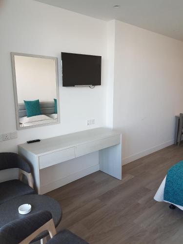 a white room with a desk and a mirror at Melini Hotel Suites in Protaras