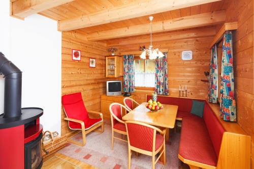 uma sala de estar com uma mesa e cadeiras e um fogão em ÖKO Feriendorf Schlierbach em Schlierbach