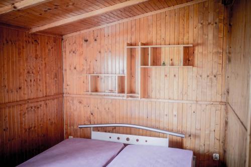 a small room with a bed in a wooden wall at Hacjenda in Łuszczewo