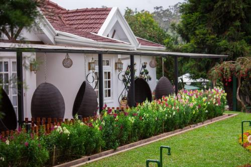 a garden in front of a house with flowers at La Grande Villa in Nuwara Eliya