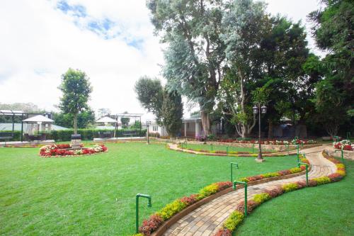 a park with a lawn with flowers and plants at La Grande Villa in Nuwara Eliya