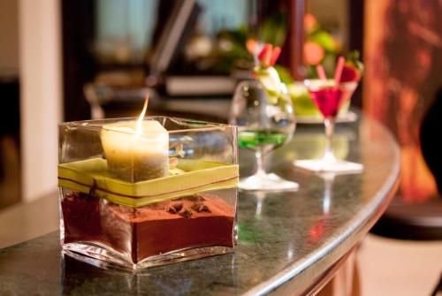 a table with a candle and two glasses of wine at AS Hotel Sempione Fiera in San Vittore Olona