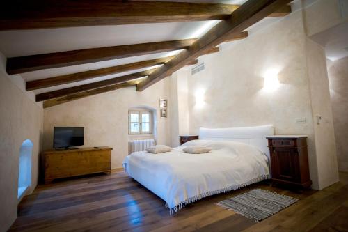 a bedroom with a white bed and a television at Villa Tona in Višnjan