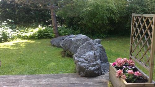 a rock and flowers on a wooden bridge at Landhaus Steinbrech in Grainau
