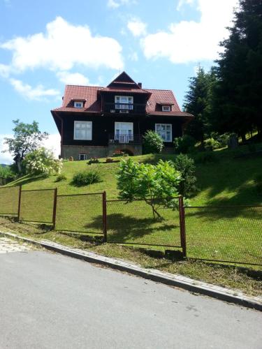 a house on a hill with a fence in front of it at Willa Marylka in Piwniczna