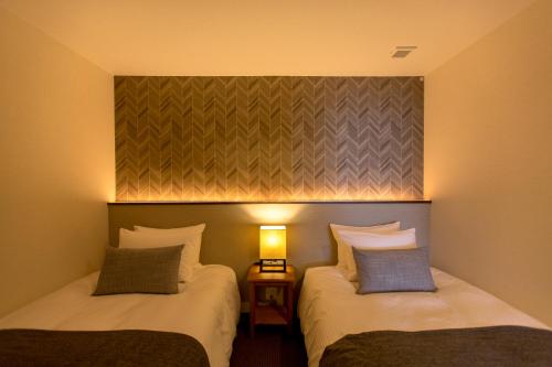 two beds sitting next to each other in a room at R&Run Kyoto Serviced Apartment & Suites in Kyoto