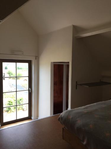 een slaapkamer met een bed en een groot raam bij Eeuwenhout vakantiedomein in Dranouter