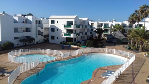 a large swimming pool in front of a building at RealRent Costa Teguise Beach in Costa Teguise