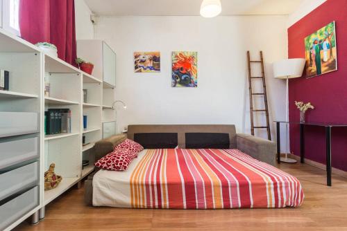 バレンシアにあるArrendamiento de temporada en Ruzafaのベッドルーム1室(カラフルな毛布付きのベッド1台付)