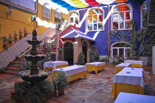a courtyard with tables and a fountain in front of a building at Hotel Plaza Manjón in Villanueva del Arzobispo