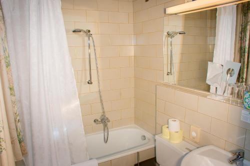 a bathroom with a tub and a sink and a shower at Gasthof Hohlwegwirt in Hallein
