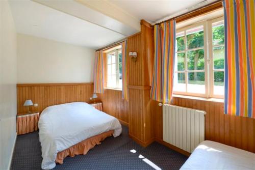 une petite chambre avec deux lits et une fenêtre dans l'établissement Le Bois de Rome, à Conches-en-Ouche