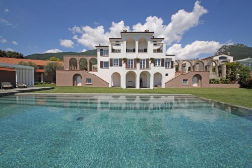 une grande maison avec une piscine en face de celle-ci dans l'établissement Le Selve Lake View Villas, à Toscolano Maderno