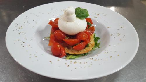 a plate of food with tomatoes and sour cream at Hotel Weber Ambassador in Capri