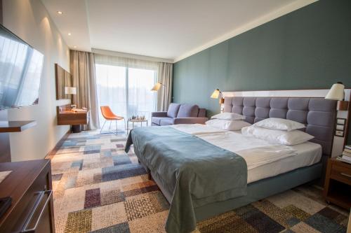 1 dormitorio con 1 cama grande y sala de estar en Hotel Aquarius SPA, en Kołobrzeg