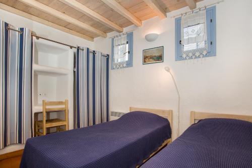 sypialnia z fioletowym łóżkiem i oknem w obiekcie Villa Yviskos Traditional Home w mieście Chrissi Akti