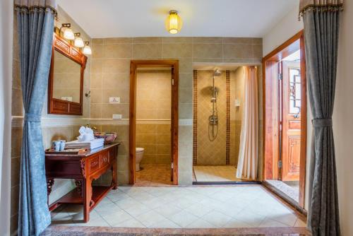 a bathroom with a shower and a sink and a desk at Yangshuo River View Hotel in Yangshuo
