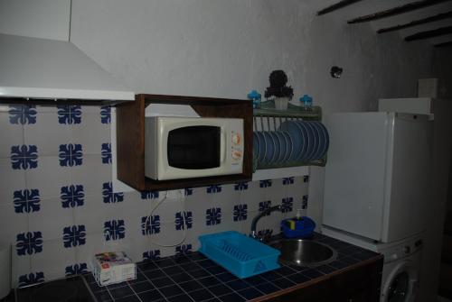 a kitchen with a microwave and a sink at Cazorla Rural in Quesada