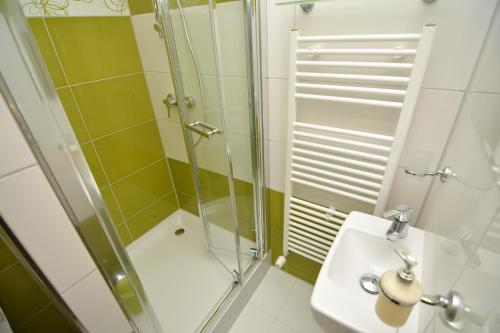 uma casa de banho com um chuveiro e um lavatório. em Vila Kamah em Tatranská Lomnica
