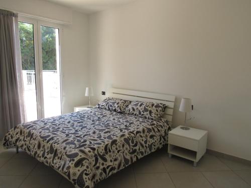 - une chambre avec un lit et une grande fenêtre dans l'établissement Bludamare, à Albenga